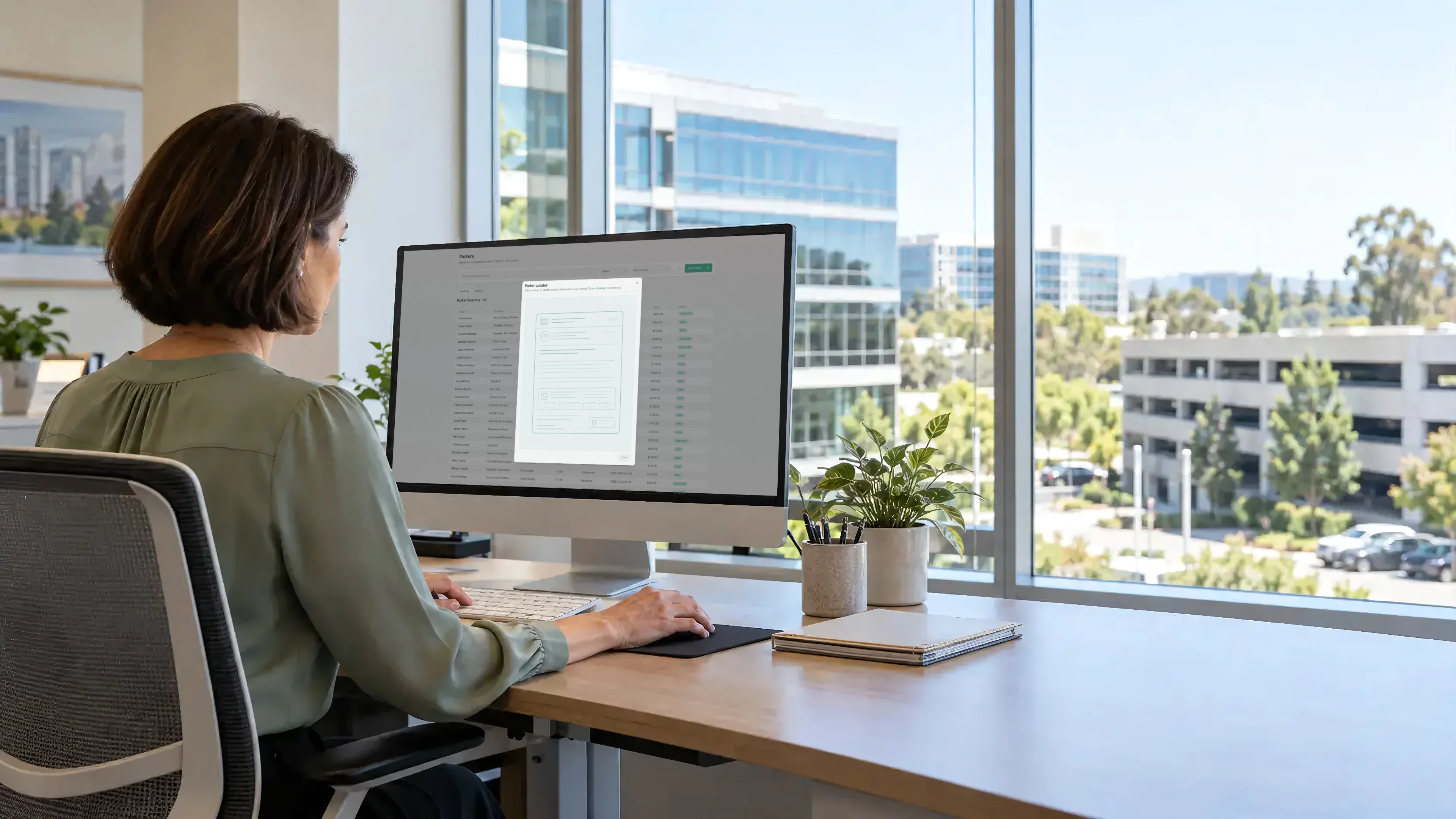 Property manager reviewing a parker import in Tandem at a bright desk with a commercial garage visible through the window